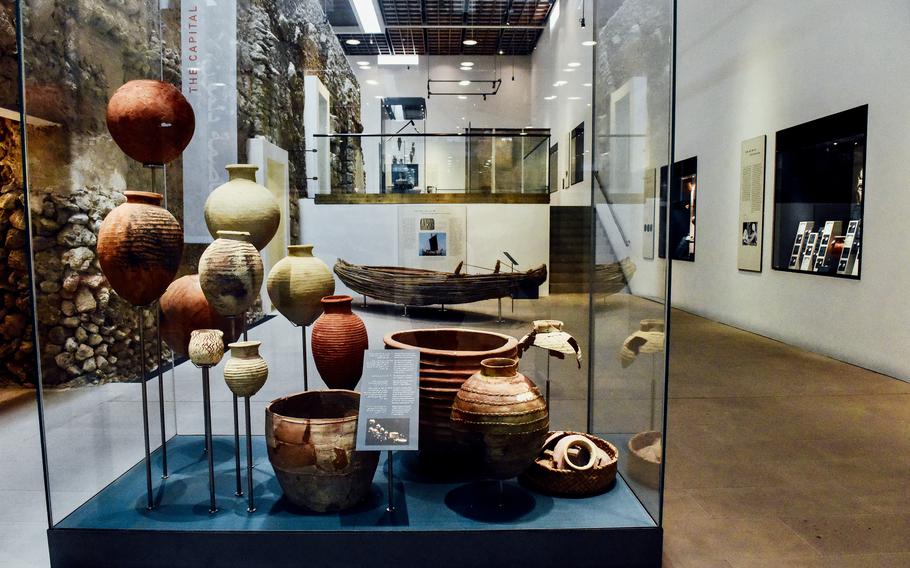 Historic pottery of various sizes is displayed in a large glass case at the Qal’at al-Bahrain museum. The Qalat al-Bahrain Site Museum features five exhibition halls displaying over 500 artifacts discovered at the Bahrain Fort. Rare restored ceramic pieces, like those shown here, are part of the collection.