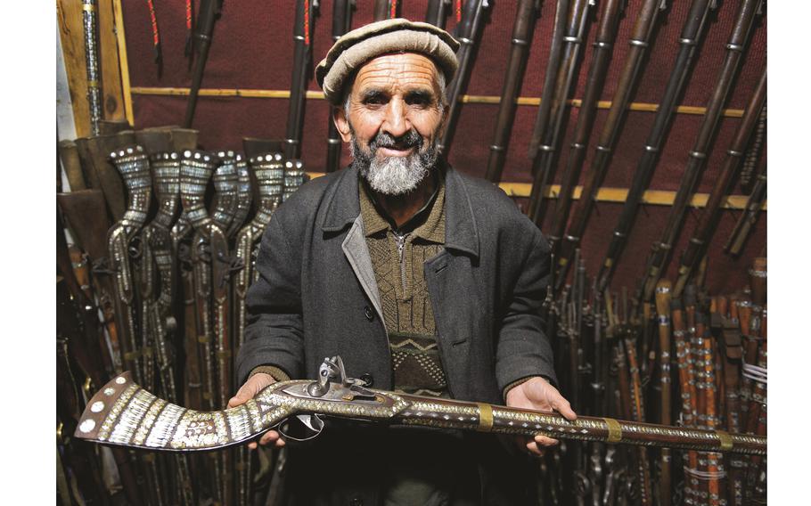 Sher Mohammed holds a replica jezail musket in his shop