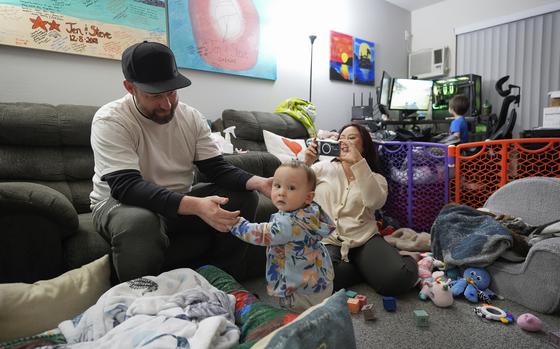 Steve Petersen, left, and his wife Jennifer watch as their daughter Carolynn tries to stand inside their apartment in Campbell, Calif., Wednesday, Jan. 15, 2025. 