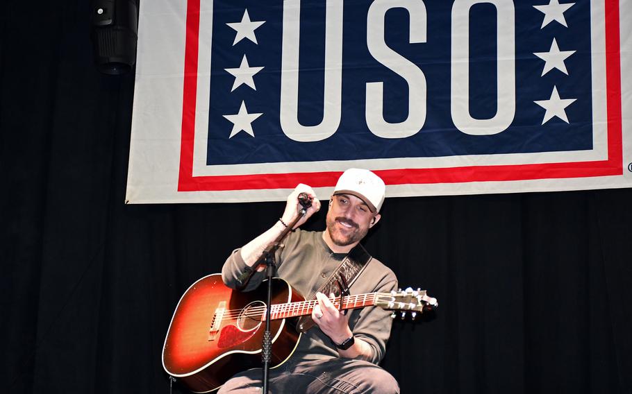 A musician plays a guitar at show in Italy.