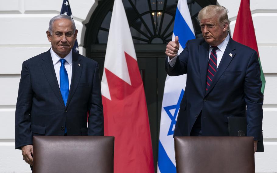 Donald Trump and Benjamin Netanyahu stand on a stage outside the White House in front of U.S. and Israeli flags.