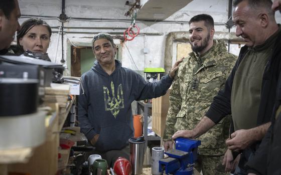 Amed Khan, a U.S. human rights advocate, political activist and philanthropist, center, listens to Yuri Fedorenko, commander of Ukraine's attack drones battalion "Achilles" in Kharkiv region, Ukraine, Sunday, Oct. 27, 2024. (AP Photo/Efrem Lukatsky)