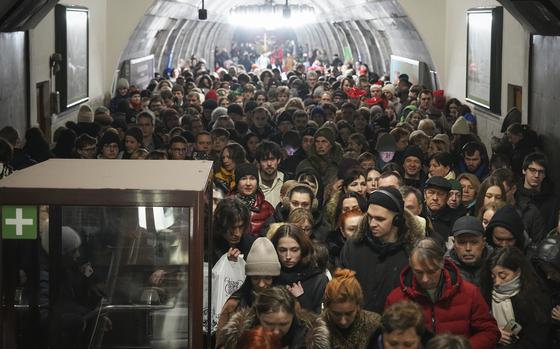 A mass of people are packed next to each other in a train station.