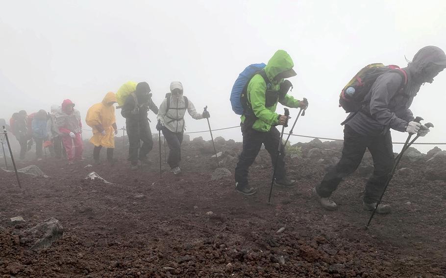 Climbers head to the summit of Mt. Fuji in bad weather.