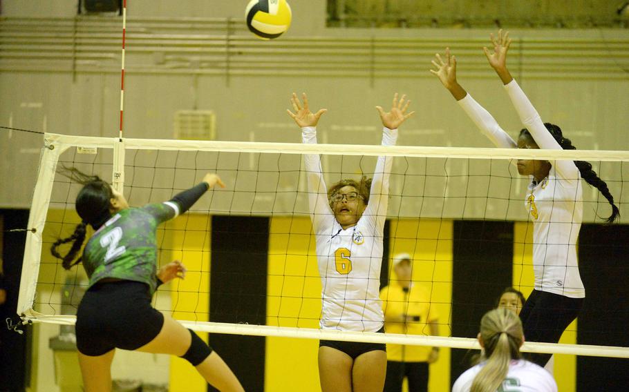 Kubasaki's Runa Holladay spikes against Kadena's Jaci Scriven and Liza Young during Tuesday's Okinawa volleyball match. The Dragons won in five sets to level the season series 1-1.