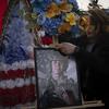 A woman holds a portrait of U.S. Marine Corps veteran Ethan Hertweck, 21, who lost his life in defending Ukraine against the Russian troops.