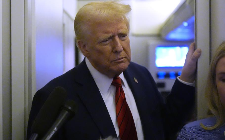 President Trump looks down while resting a hand on a door frame.