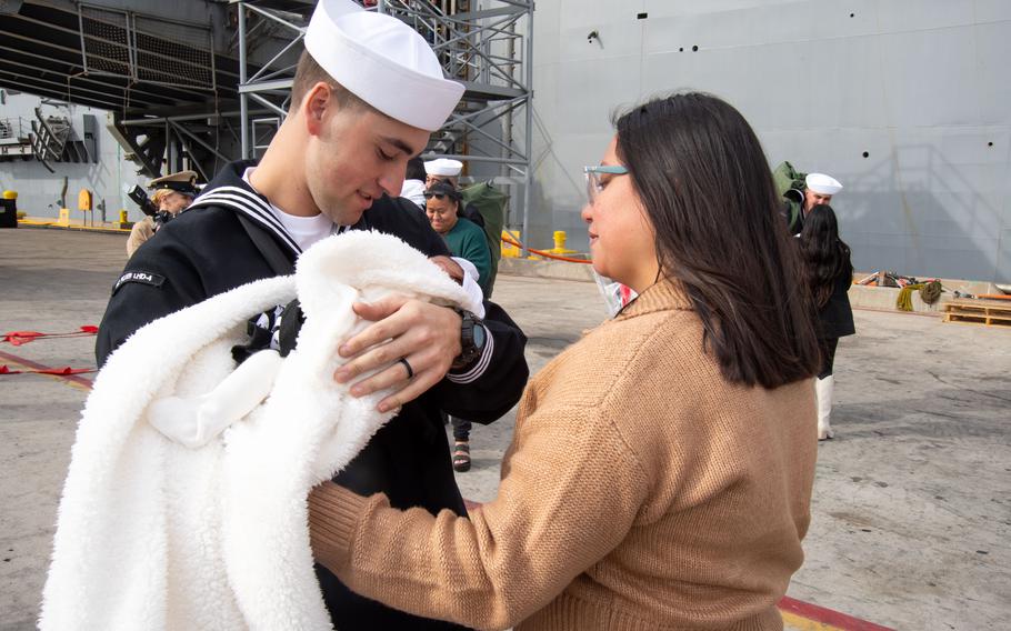 A sailor greets his family on the pier 