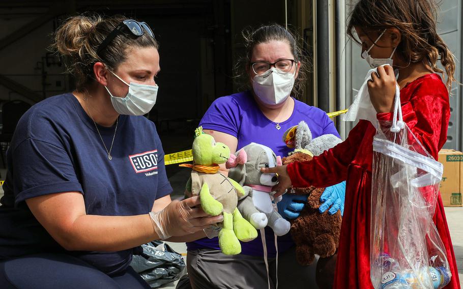 USO volunteers offer stuffed toys to an evacuee from Afghanistan as she arrives at Naval Air Station Sigonella, Italy, Aug. 28, 2021. 