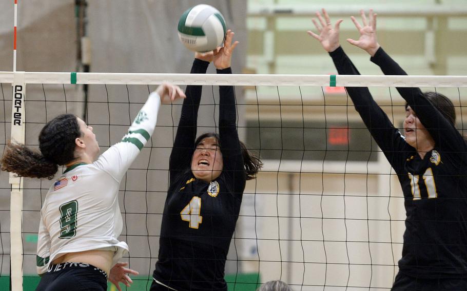 Kubasaki's Olivia Schaffeld spikes against Kadena's Mai Leddy and Leighton Botes during Tuesday's Okinawa volleyball match. The Dragons won in four sets.