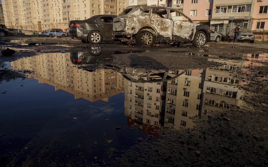 Destroyed cars are reflected in a pool of water after a Russian airstrike on residential neighbourhood in Sumy, Ukraine, on Saturday, Aug. 17, 2024. 