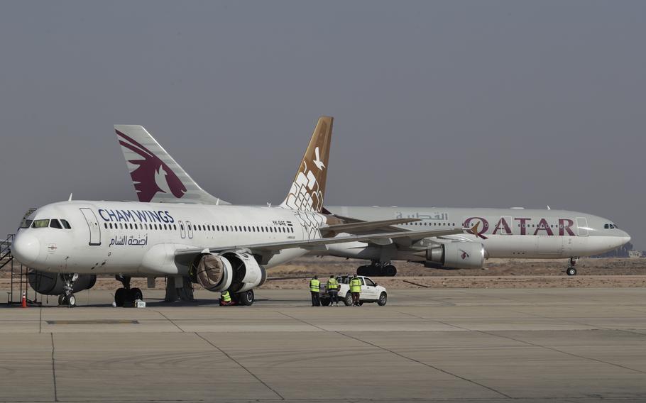 Two airplanes face in different directions on the tarmac at the main airport in Damascus.