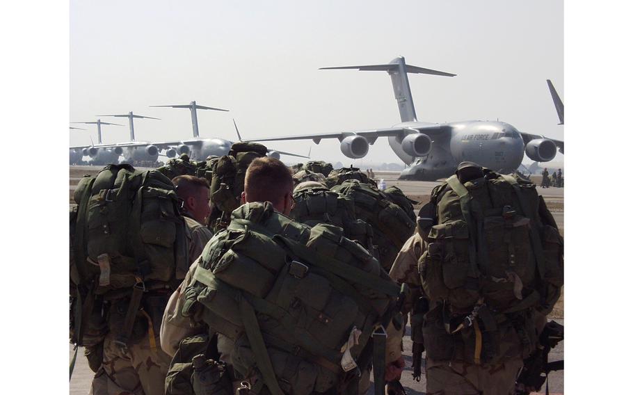 Members of the 173rd Airborne Brigade move toward C-17 transport planes Wednesday afternoon on the taxiway at Aviano Air Base, Italy. The Vicenza-based troops parachuted into northern Iraq Wednesday.