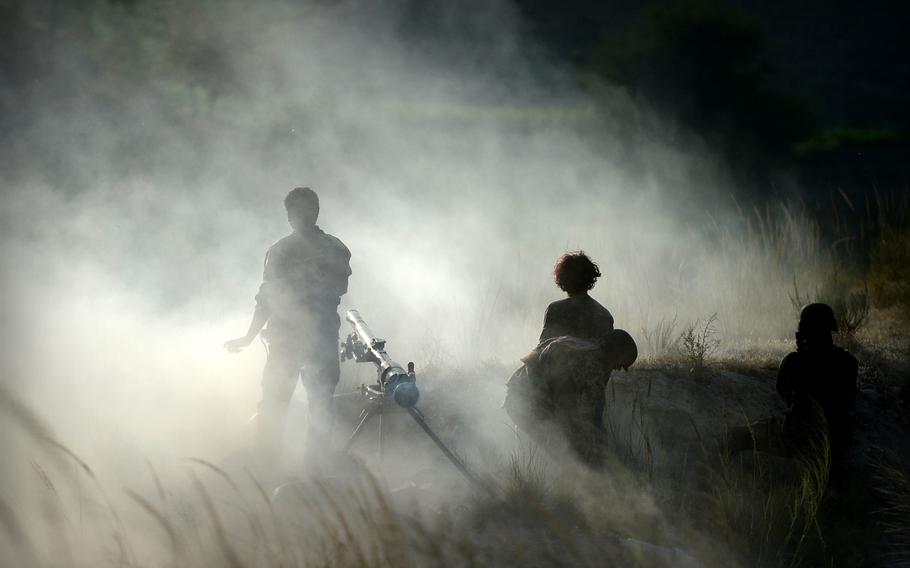 Smoke and dust surround soldiers in Afghanistan