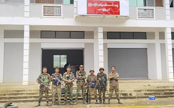 In this handout photo provided by Mandalay People's Defence Force, members of the Ta'ang National Liberation Army, one of the ethnic armed forces in the Brotherhood Alliance, and the Mandalay People's Defence Force pose for a photograph in front of the captured building of the Myanmar War Veterans' Organisation in Nawnghkio township in Shan state, Myanmar, June 26, 2024. New fighting has broken out in northeastern Myanmar, bringing an end to a Chinese-brokered cease-fire and putting pressure on the military regime as it faces attacks from resistance forces on multiple fronts in the country's civil war. 