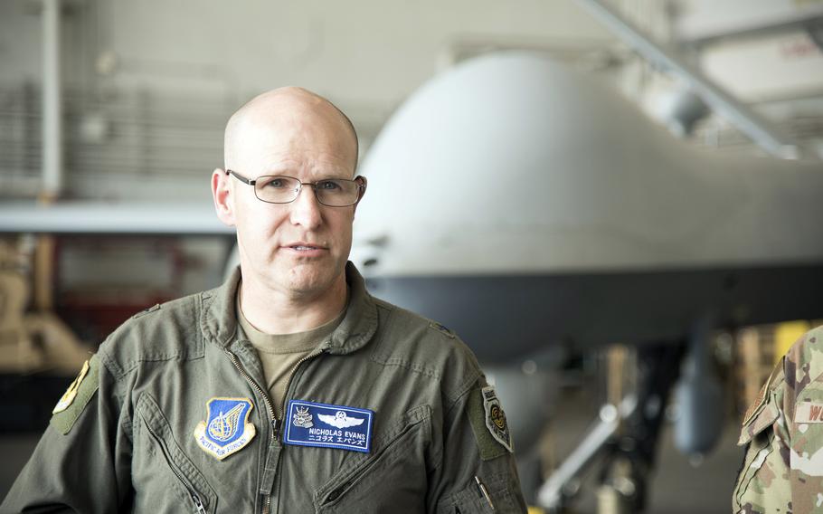 The commander of the 18th Wing speaks with reporters inside a hangar at Kadena Air Base.