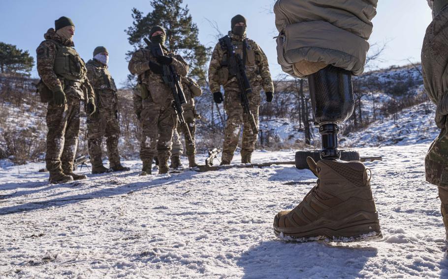 A soldier with a prosthetic leg speaks to soldiers during military training 