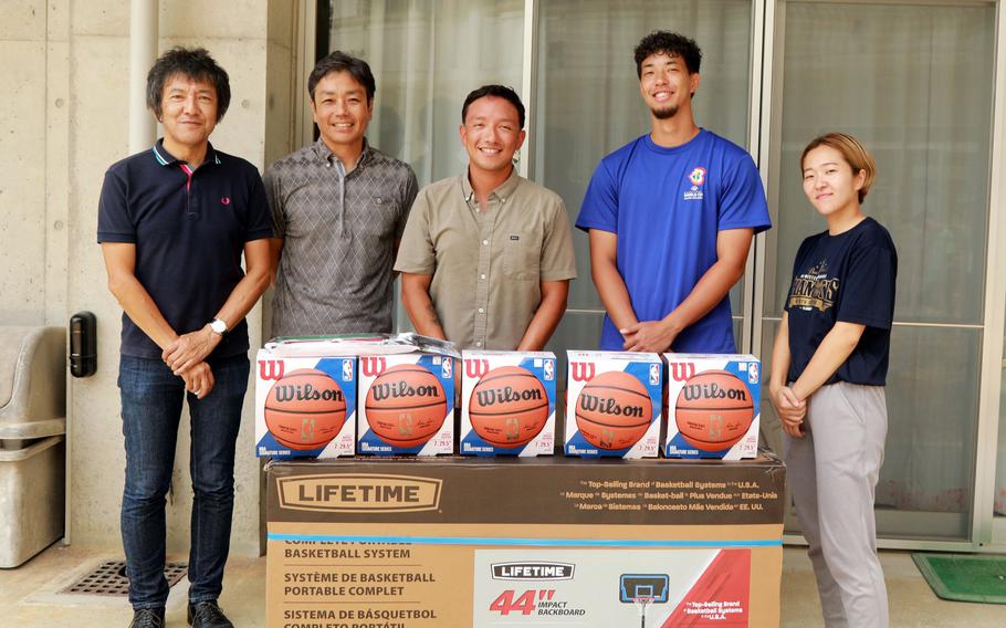 Marine Gunnery Sgt. Mario Sanchez Jr., center, poses with Urawa Women's Shelter staffers in Urasoe city, Okinawa, after donating a basketball goal and five balls on Aug. 28, 2024