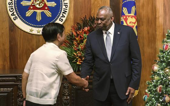 Philippine President Ferdinand Marcos Jr. shakes hands with U.S. Defense Secretary Lloyd Austin.