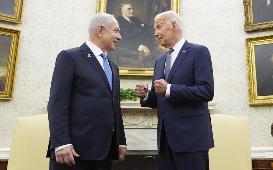 Joe Biden and Benjamin Netanyahu speaks in the Oval Office in front of portraits of former presidents.