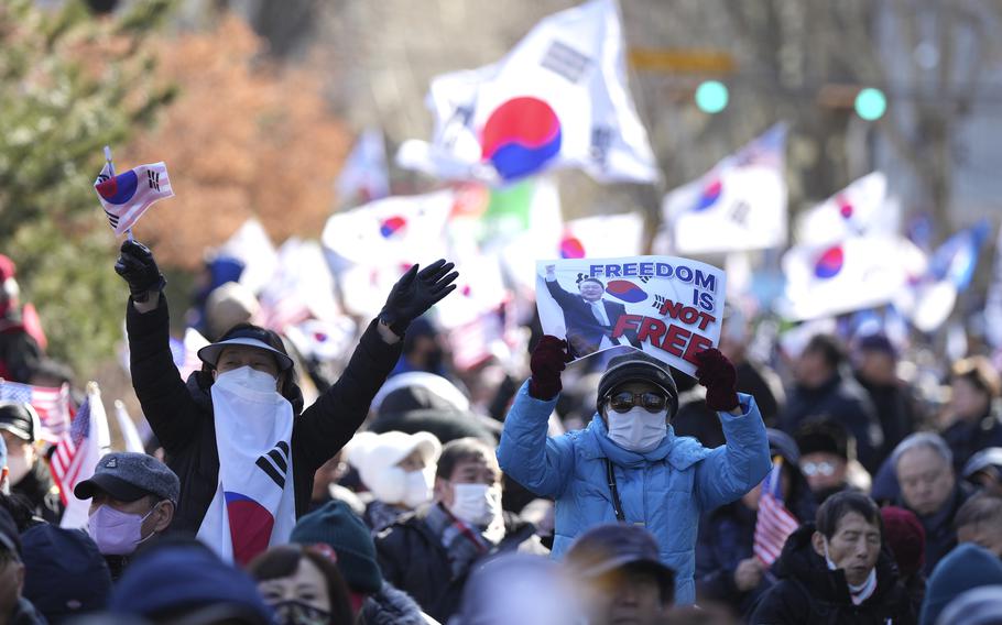 Supporters of impeached South Korean President Yoon Suk Yeol hold signs during a rally