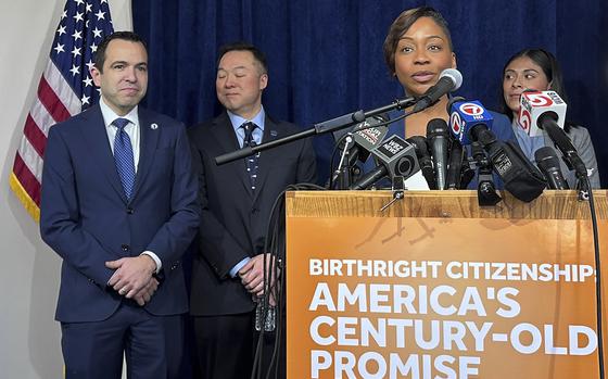 A woman speaks at a podium that has a sign reading “Birthright citizenship: America’s century-old promise.”