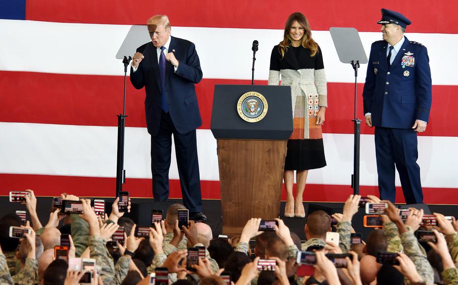 President Donald Trump stands on a stage at Yokota Air Base with first lady Melania Trump and Lt. Gen. Jerry Martinez, then-U.S. Forces Japan commander. 