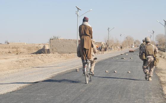 Marjah, Afghanistan, Jan. 23, 2011: An Afghan translator working for the Marines takes a local boy for a bike ride on the boy's bike on Marjah's main drag. The road had just been paved, a first in the town.

Check out Nancy Montgomery's 2011 on the progress made at the time in Marjah here.
https://www.stripes.com/migration/one-year-after-offensive-signs-of-progress-in-marjah-1.134822

META TAGS: Operation Enduring Freedom, War on Terror, Afghanistan, Afghan,