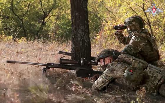 A Russian sniper fires toward Ukrainian forces.