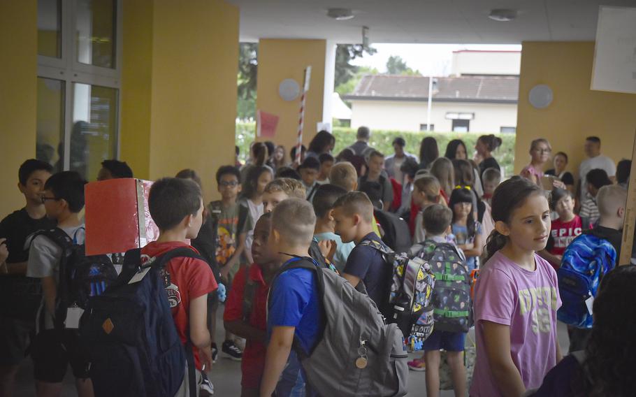 Students wait outside in the hallway before the first day of classes at Aviano Elementary School on Aug. 19, 2024. They were able to escape a light rain and put away umbrellas and rain jackets before entering the school a few minutes later.