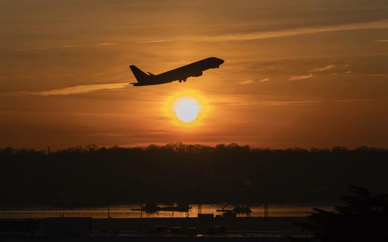 The sun rises and a jet lifts off above a wreckage site in the Potomac River from Ronald Reagan Washington National Airport, Monday, Feb. 3, 2025, in Arlington, Va. (AP Photo/Jose Luis Magana)