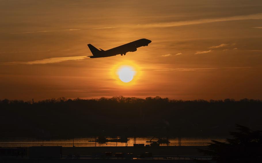 The sun rises and a jet lifts off above a wreckage site