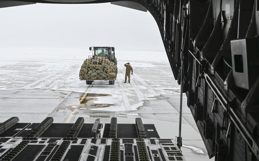 Airmen loads the back of an aircraft with supplies.