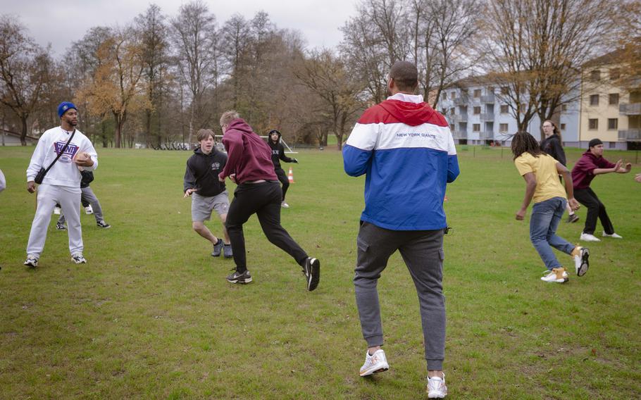 Brandon London, a former wide receiver for the New York Giants, plays quarterback for Vilseck High School students at Rose Barracks, Germany, 