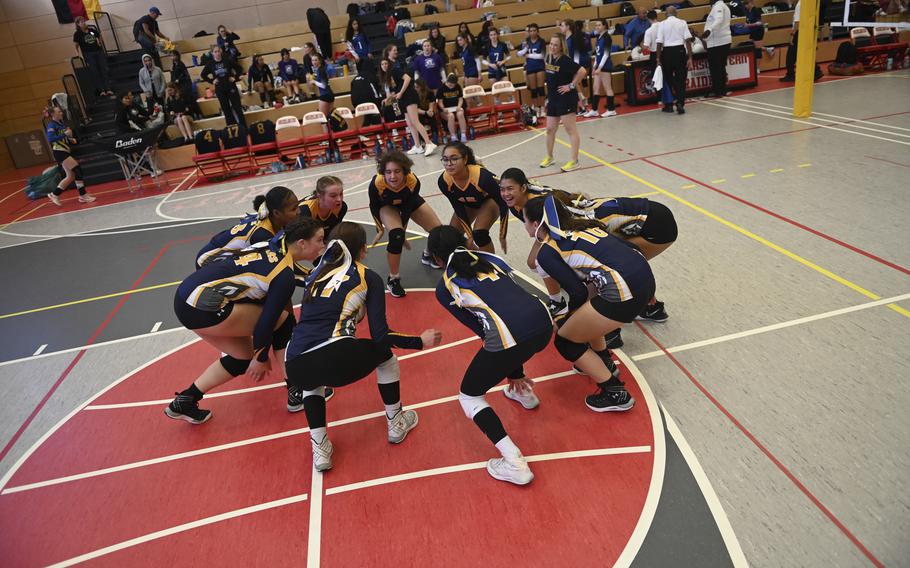 The Ansbach Cougars revel in their victory with a jubilant circle dance, while head coach Deb Keller-Mitchell observes the celebration, following their match at the DODEA Division III European volleyball semifinals on Oct. 27, 2023, in Kaiserslautern, Germany.