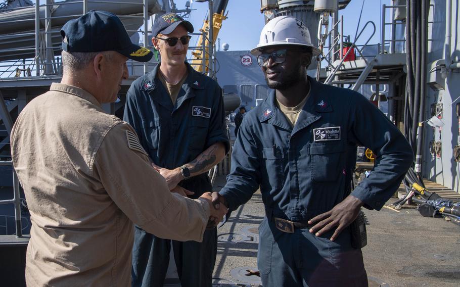 Rear Adm. Ted LeClair, deputy commander, Naval Surface Forces, U.S. Pacific Fleet, shakes hands with Boatswain’s Mate 2nd Class Matthew Wattara.