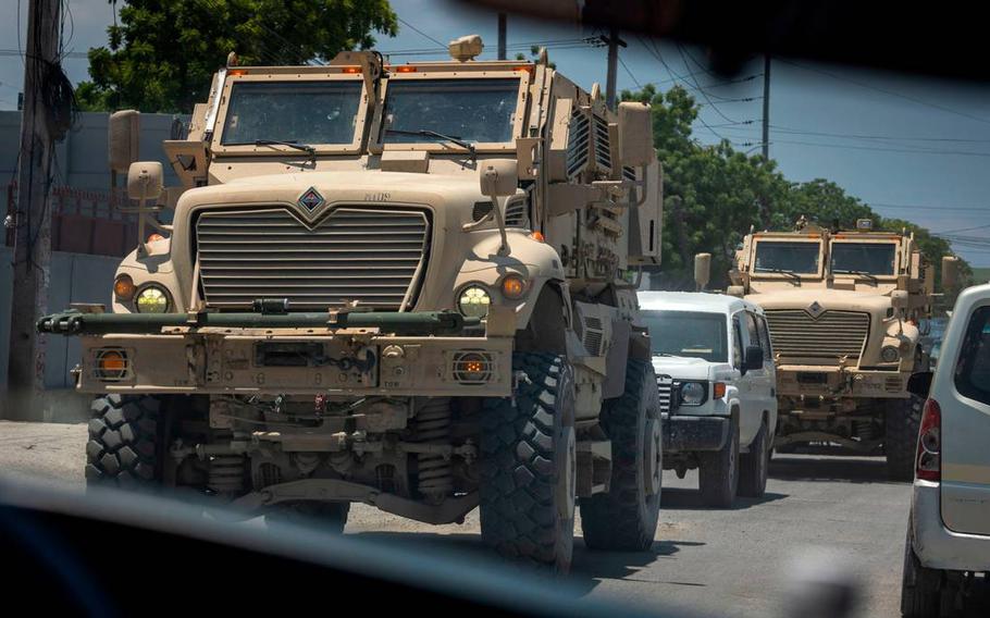 Armored vehicles used by Kenyan police rumble through the streets of Port-au-Prince, Haiti.