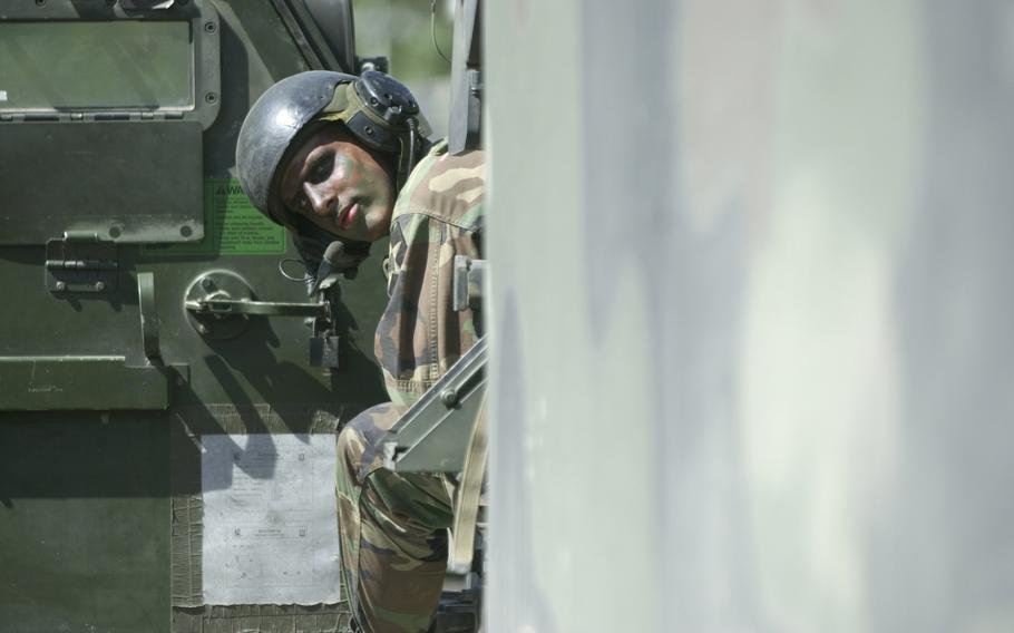 Soldier looks back from a multiple launch rocket system vehicle