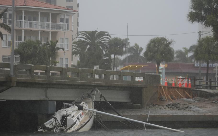 A damaged boat rests as heavy winds from Hurricane Milton approach South Pasadena, Fla.