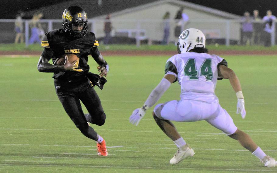 Kadena quarterback DeShaun Nixon tries to avoid Kadena defender Tre Johnson.