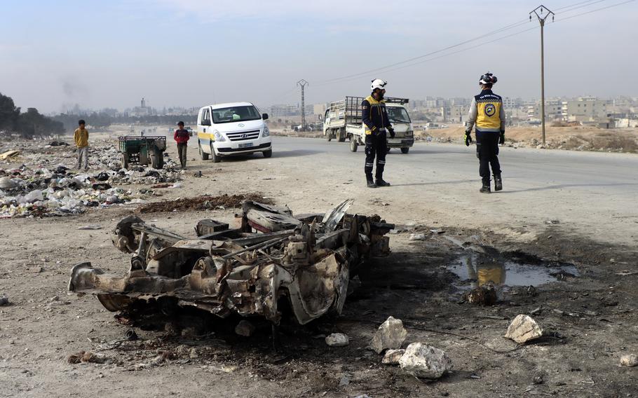 Syrian White Helmet civil defense workers inspect the area of a car bomb attack