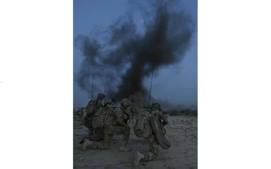 Soldiers with Company C, 1st Battalion, 32 Infantry Regiment, 3rd Brigade Combat Team, 10th Mountain Division move forward after an anti-personnel obstacle breaching system is blown at dawn.