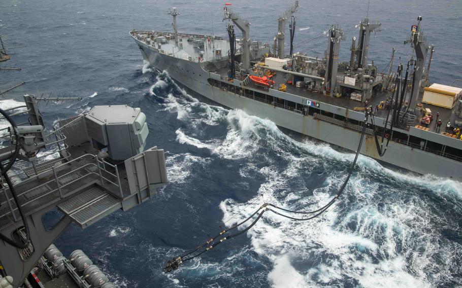 The USNS John Ericsson, a Military Sealift Command replenishment oiler, sends a fuel line to the aircraft carrier USS Ronald Reagan for a fueling-at-sea in the Philippine Sea on May 23, 2024. 