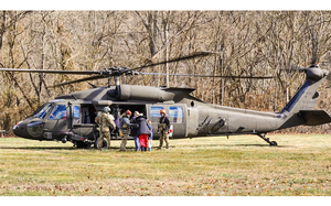 Troops help people onto a helicopter.