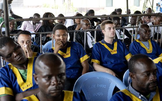 FILE - Back row from left, Benjamin Reuben Zalman-Polun, Marcel Malanga and Tyler Thompson, all American citizens, attend a court verdict in Congo, Kinshasa, Friday, Sept. 13, 2024, on charges of taking part in a coup attempt in May 2024. (AP Photo/Samy Ntumba Shambuyi, File)