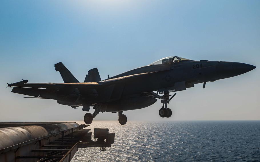 A fighter jet launches off of a ship.