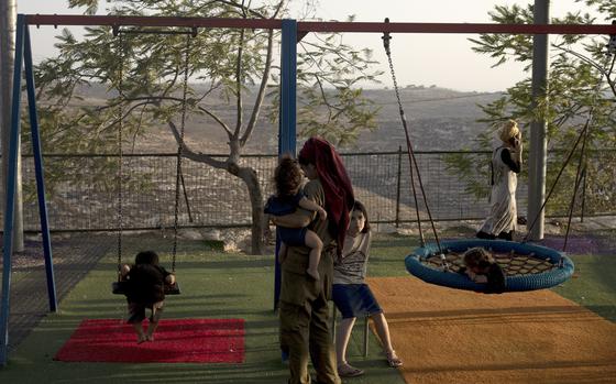 Women and their children gather in the playground at the end of the day in the settlement outpost of Asa'el in the south Hebron hills on Monday, Sept. 4, 2023. The Israeli government has budgeted millions of dollars in security support for small, unofficial Jewish outposts in the Israeli-occupied West Bank, which is enabling the expansion of Jewish settlements while circumventing the official planning process, according to a human rights group.
