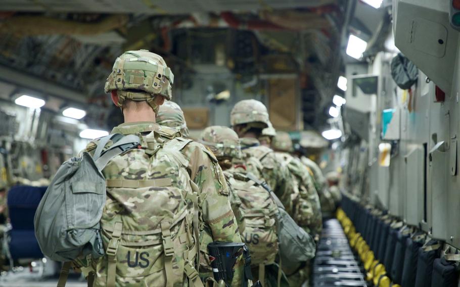 Soldiers walking onto an aircraft.