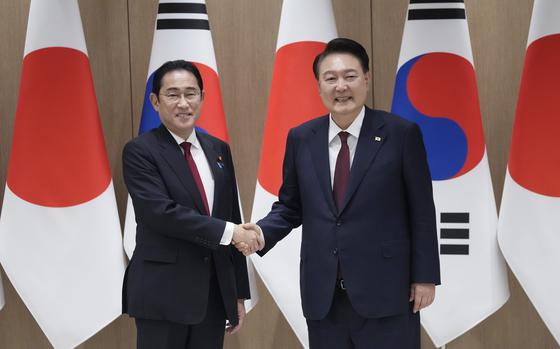 South Korean President Yoon Suk Yeol, right, shakes hands with Japanese Prime Minister Fumio Kishida during a meeting at the Presidential Office in Seoul, South Korea, on May 26, 2024.