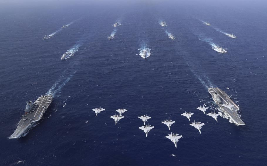 Chinese aircraft carriers sail in formation in the ocean.